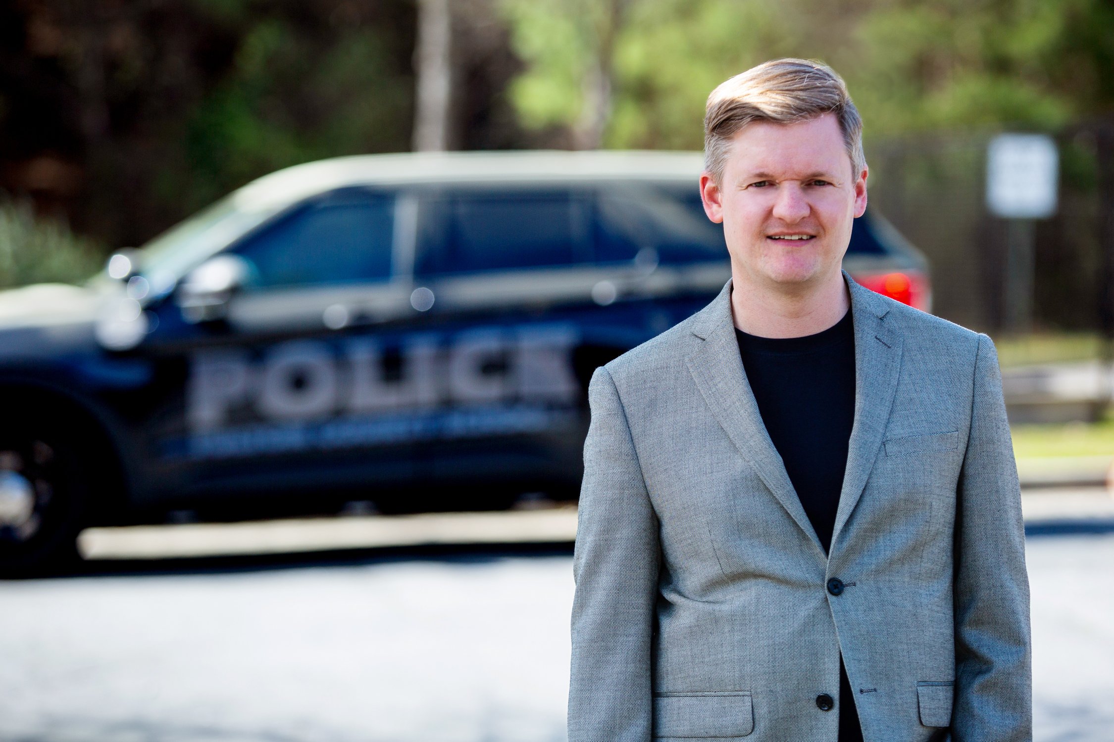 Tim Dorr in front of a police car discussing public safety
